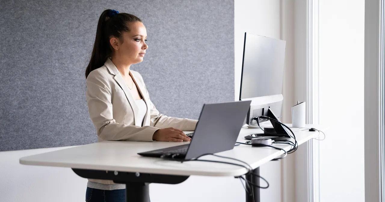 Office worker using a laptop at a standing desk